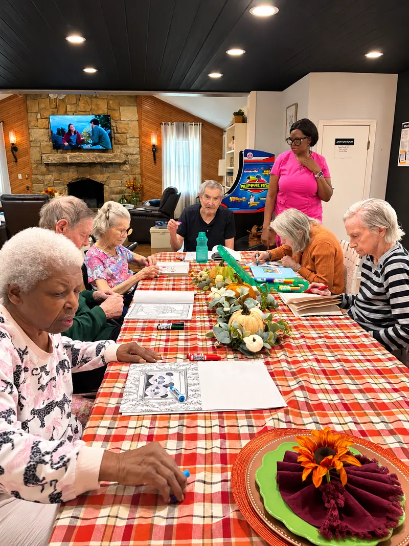 Residents coloring together at a table decorated for fall.