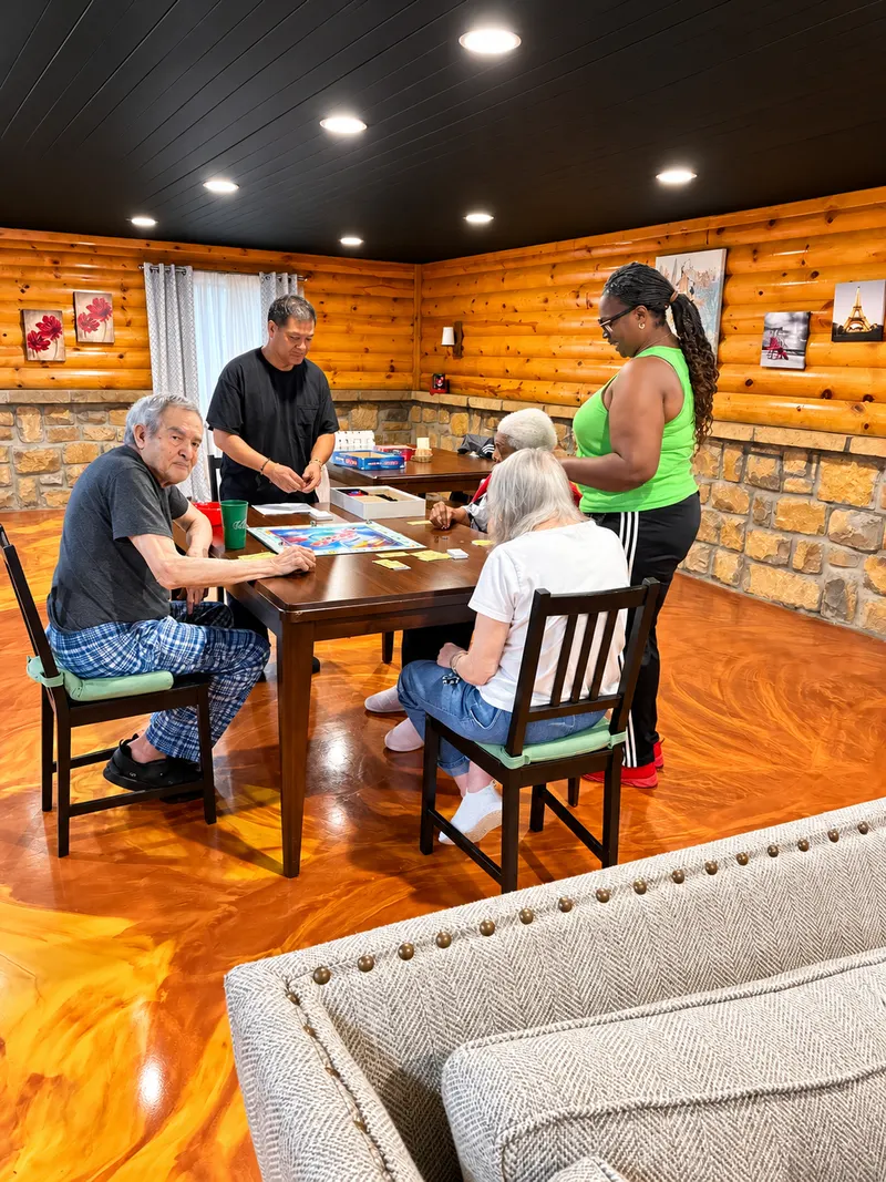 Residents and staff playing a board game in the downstairs game room.